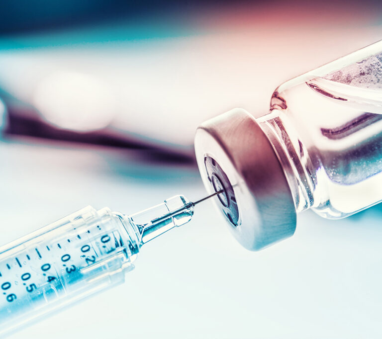 Close up medical syringe with a vaccine.