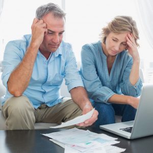 Worried,Couple,Paying,Their,Bills,Online,With,Laptop,At,Home